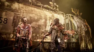 Décor du spectacles Monarques, deux comédiens devant un train de marchandises