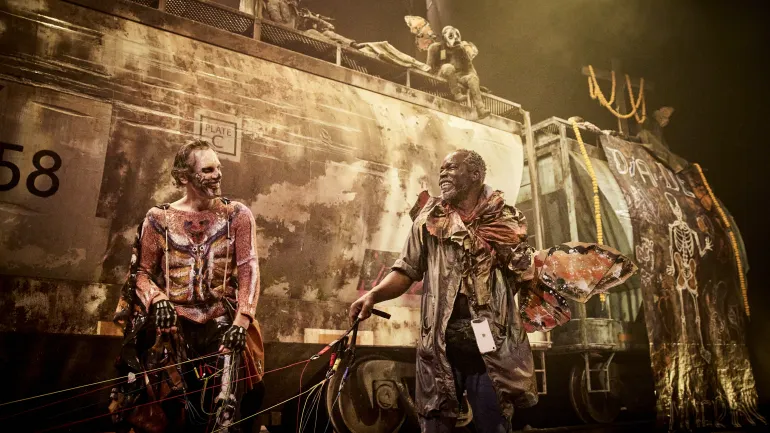 Décor du spectacles Monarques, deux comédiens devant un train de marchandises