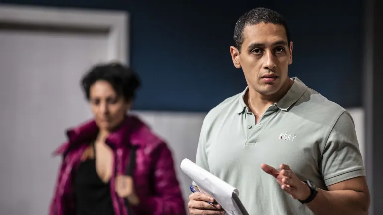 Comédien tenant un carnet et récitant son texte face caméra