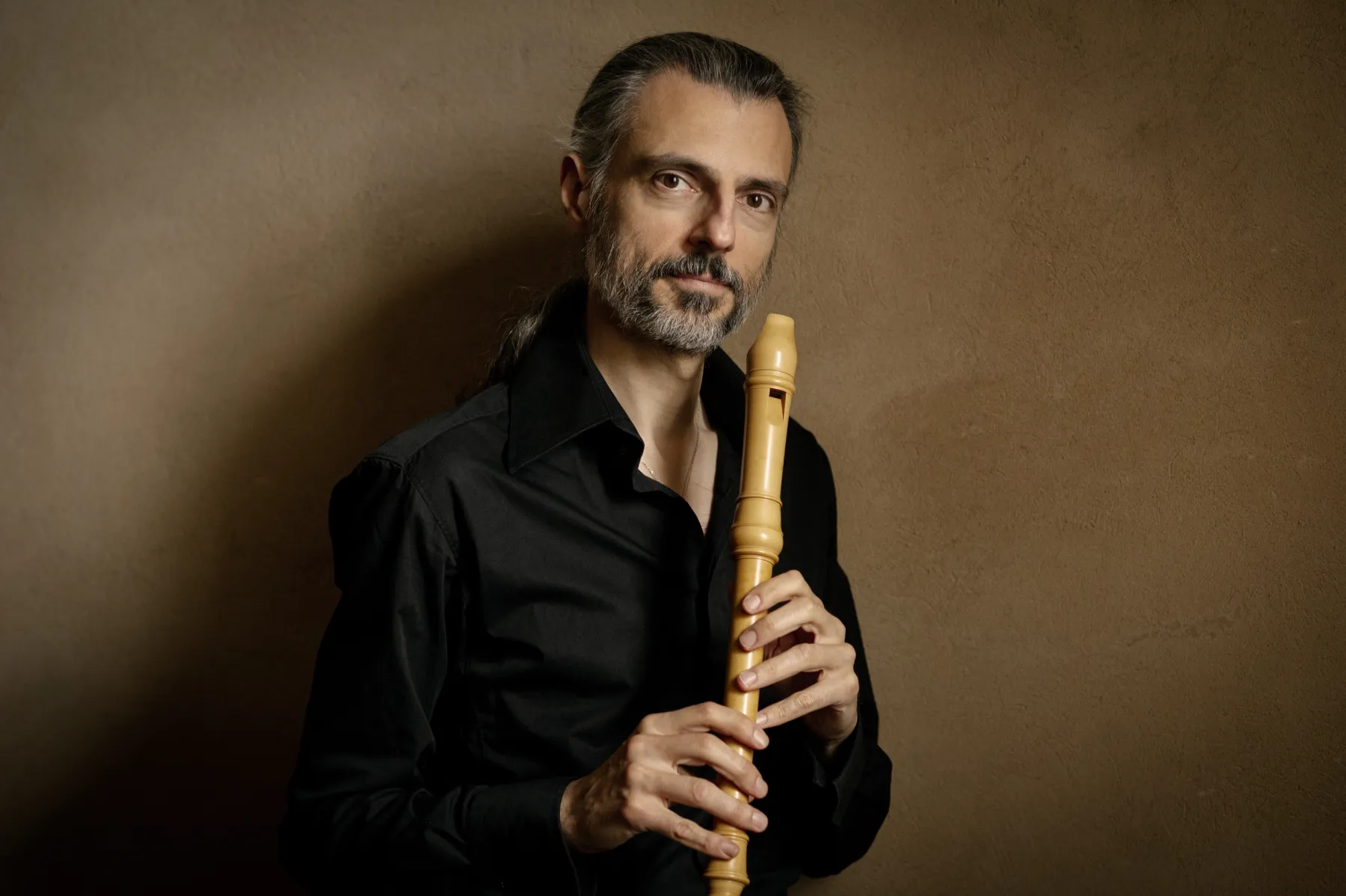 Portrait de François Lazarevitch portant une flûte et regardant la caméra